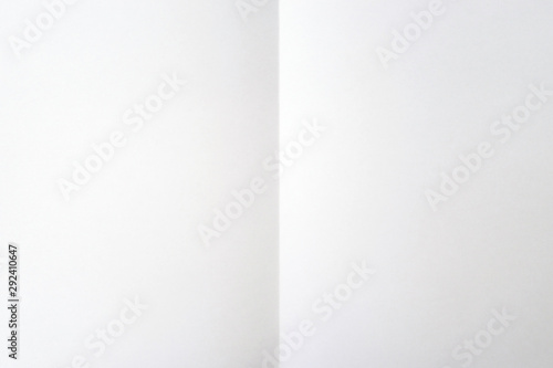 Blank white sheet of paper folded in half. White background. Place for text, copy space