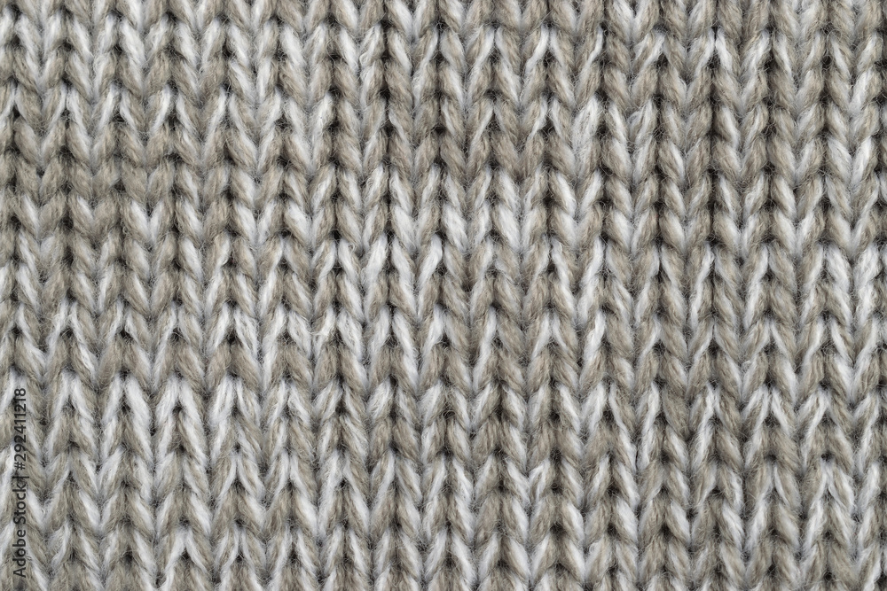 White and light brown melange yarn fabric knitted texture. Marl wool knitting background. Closeup White and light brown melange yarn fabric knitted texture. Marl wool knitting background. Closeup