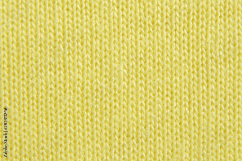 Yellow knitted background. Jersey texture. Closeup