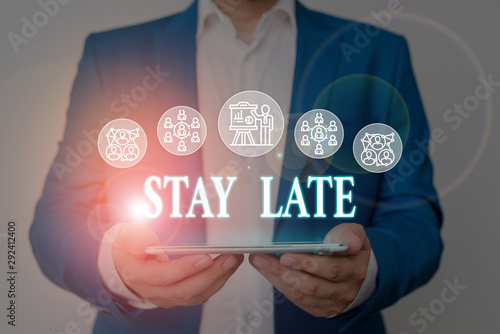 Writing note showing Stay Late. Business concept for A routine in which a demonstrating goes to somewhere out of time Male wear formal work suit presenting presentation smart device photo