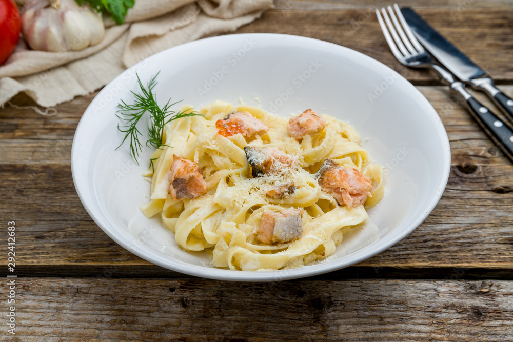 fettuccine with salmon on wooden table