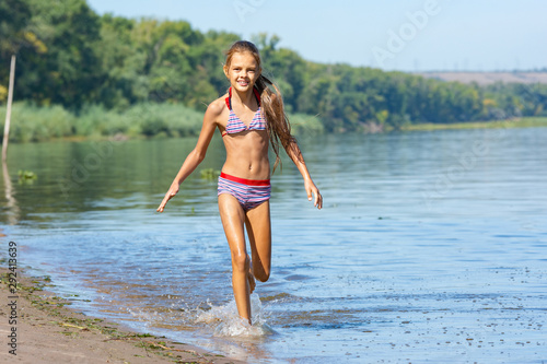 Ten year old girl runs along the river