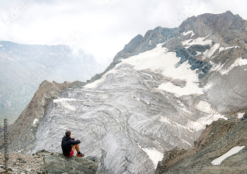Man watching glacier in italian Alps. Gran Paradiso National Park. Italy