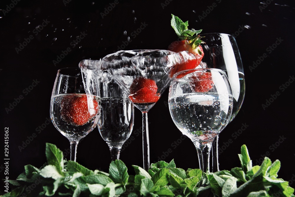 White martini cocktail splashing into glass on black background