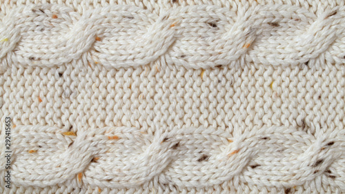 Fotografie Beige melange yarn knitted texture background. Purl and cables