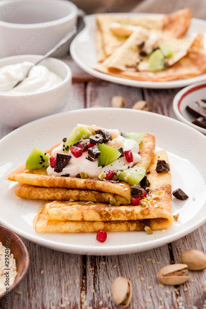 Thin Crepes with melted chocolate, sesame seeds, pomegranate and almonds. Tasty thin pancakes Thin Crepes with melted chocolate, sesame seeds, pomegranate and almonds. Tasty thin pancakes