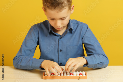 The child solves the problem of mental arithmetic on soroban photo