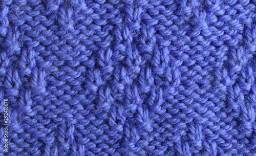 Blue wool yarn knitted texture with large stitches. Hand knitted "rhombus" background. Closeup