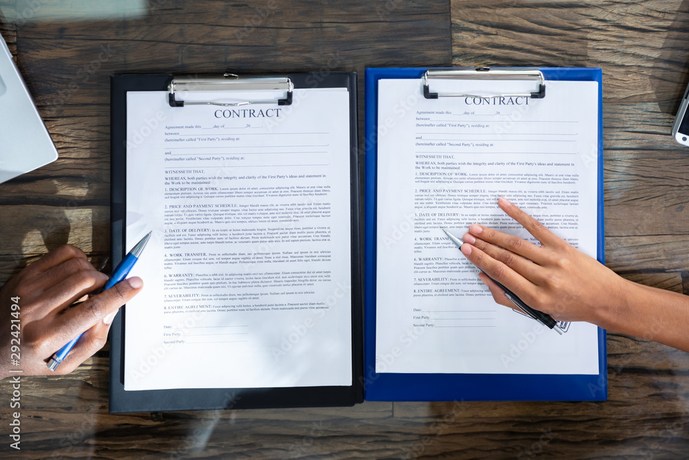 Obraz premium Two Businesspeople Working On Contract Paper