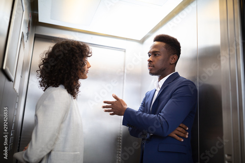 Businesspeople Having Conversation In Elevator photo