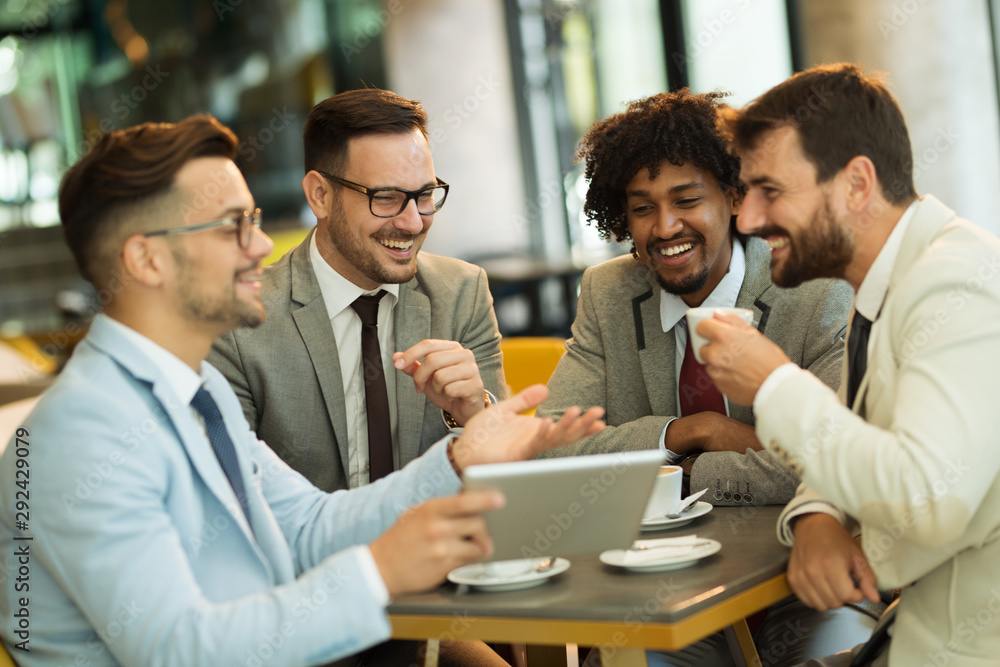 Young businessmen sitting at a coffee shop and talking about business Young businessmen sitting at a coffee shop and talking about business