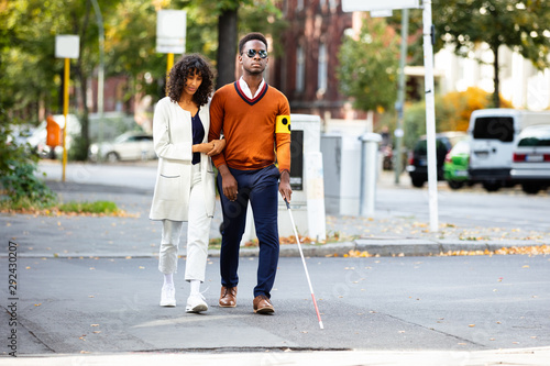 Woman Assisting Blind Man On Street