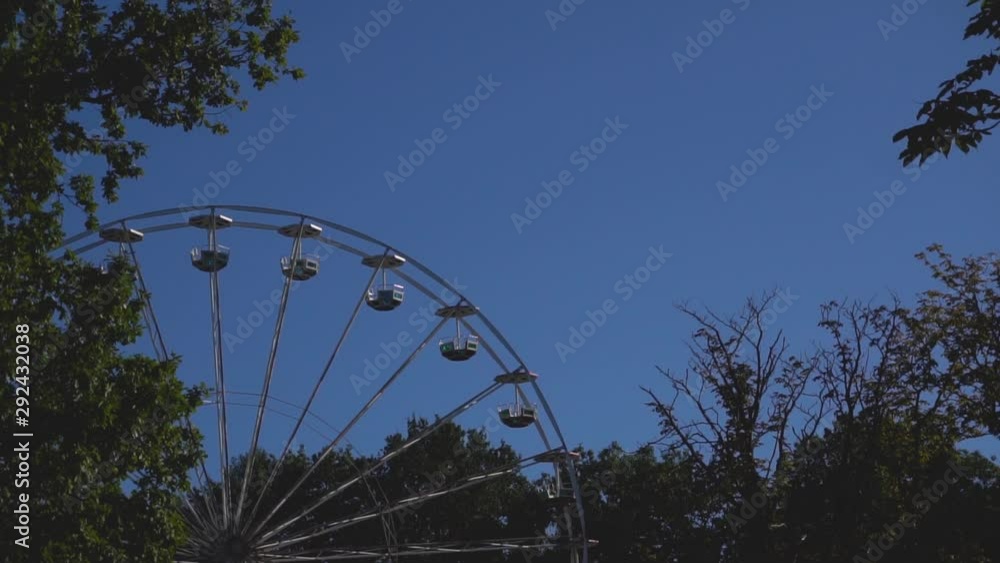 The Ferris wheel can be seen through the autumn trees in the city Park of culture The Ferris wheel can be seen through the autumn trees in the city Park of culture