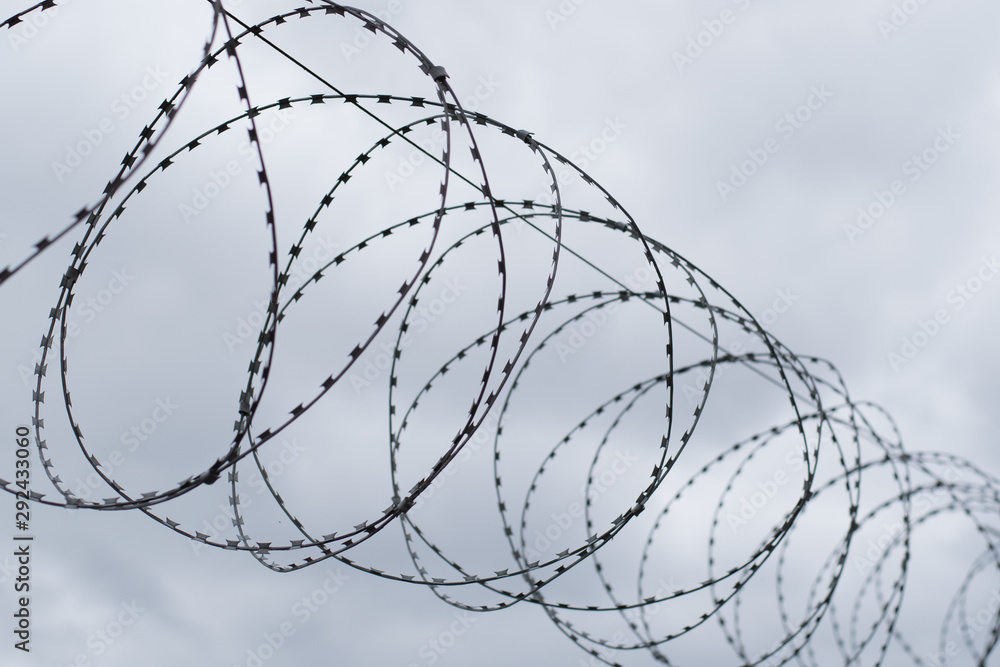 Barbed wire fence against the sky. Caution, danger zone. Barbed wire fence against the sky. Caution, danger zone.