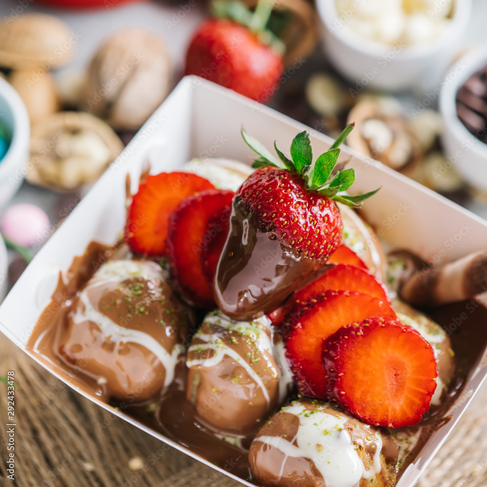 Fototapeta premium turkish lokma turkish bite dessert with chocolate and white chocolate sauce. strawberry and banana new generation bite