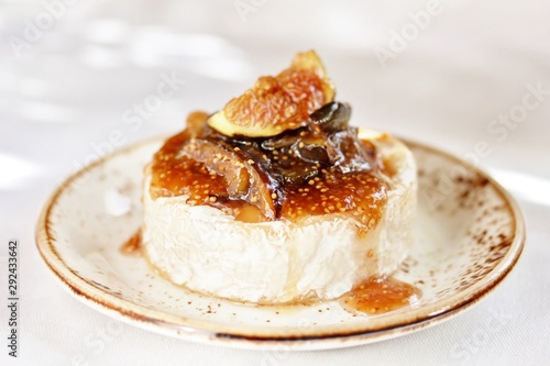 Baked Camembert cheese with fig jam and fresh figs, hard sunlight, deep shadow. sunny weather. fashion light, copy space