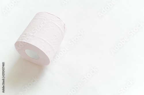 白バックの左寄りに1ロール転がるように置いてあるピンクの新品のトイレットペーパー