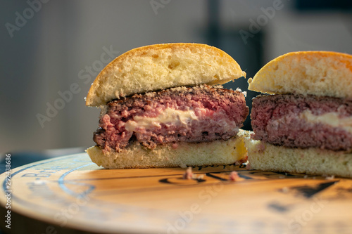 Delicious halved jucy lucy burger stuffed with cheese on a wooden board photo