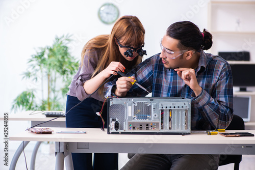 Two repairmen repairing desktop computer