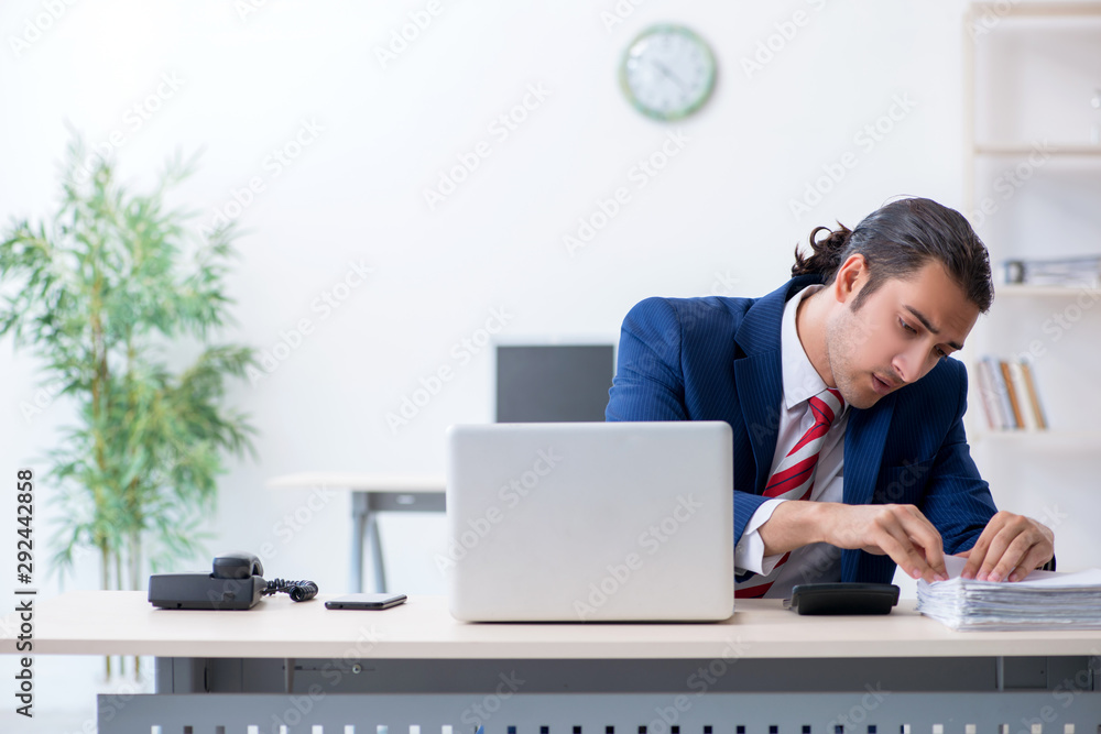 Young male businessman sitting in the office Young male businessman sitting in the office