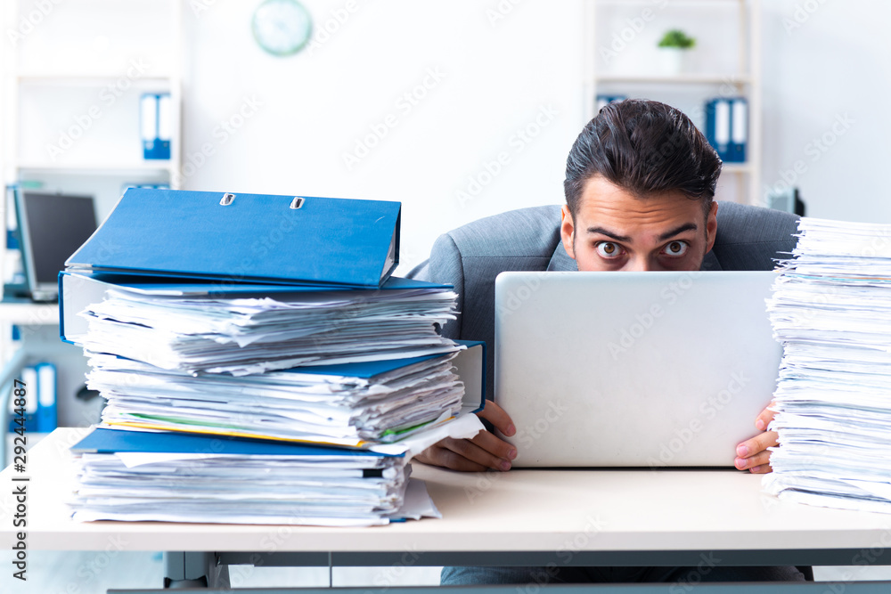 Businessman with heavy paperwork workload Businessman with heavy paperwork workload