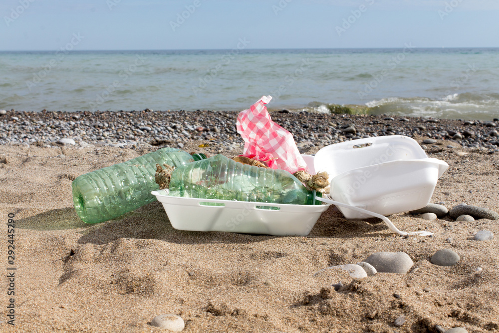 single use plastic pollution washed up on a beach, water bottles