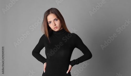 Fotografia young brown hair serious woman in black turtleneck isolated on gray studio backg