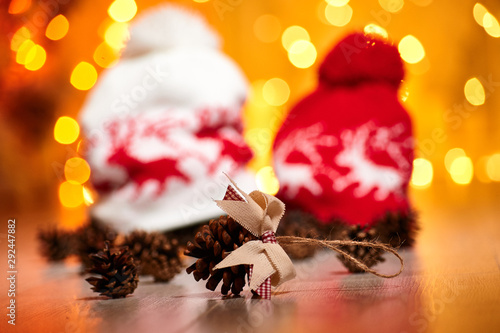 Christmas tree toy and fir cone against the backdrop of knitted hats and New Year's lights. New Year's celebration.