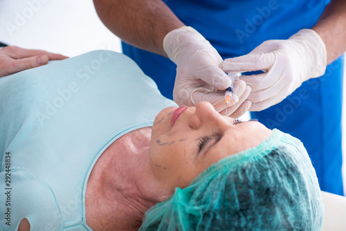 Old woman visiting male doctor for plastic surgery