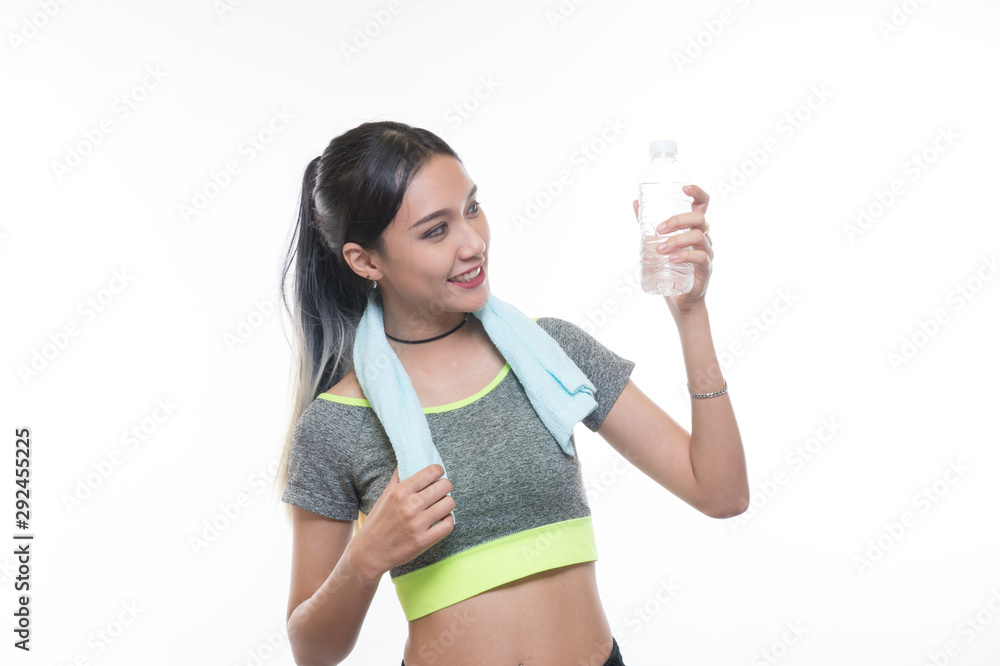 charming young girl in sports is smiling and hanging a towel and showing bottle of water, Healthy concept, Studio light portrait. charming young girl in sports is smiling and hanging a towel and showing bottle of water, Healthy concept, Studio light portrait.