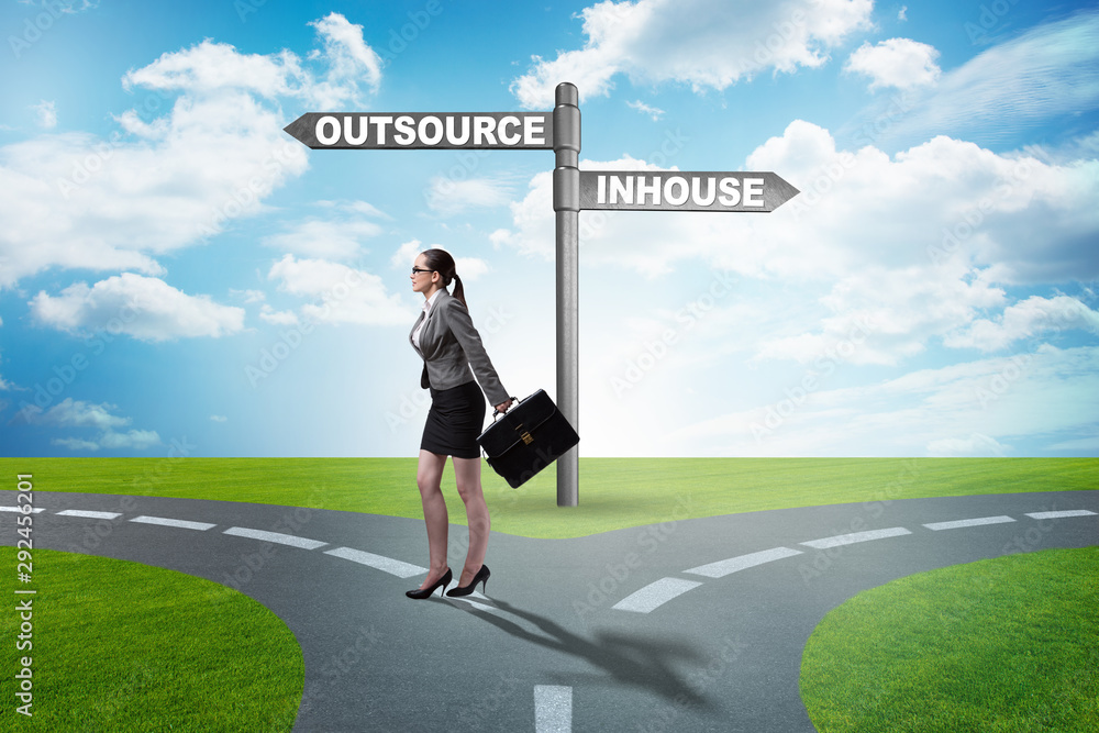 Businesswoman at crossroads deciding between outsourcing and inh Businesswoman at crossroads deciding between outsourcing and inh