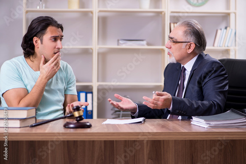 Young man visiting experienced male lawyer