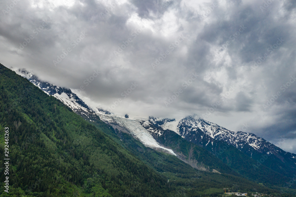 Alpine mountains and Chamonix valley under cloudy sky 