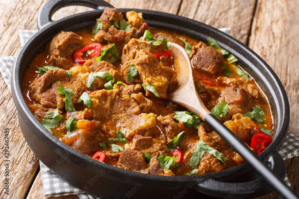 Boneless Lamb slow cooked with yogurt and traditional Indian warm spices close-up in a pan. horizontal