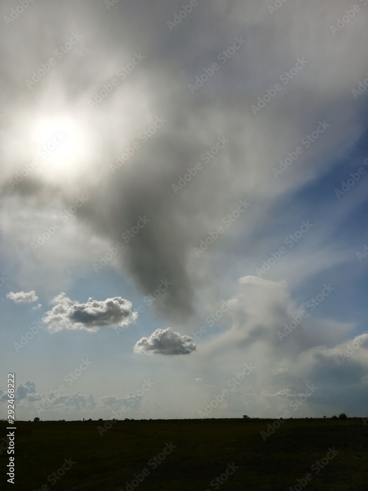 Beautiful big clouds in blue sky over river and steppe, autumn, reeds Beautiful big clouds in blue sky over river and steppe, autumn, reeds