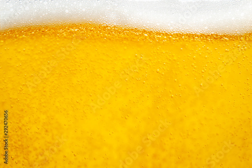 Pouring beer with bubble froth in glass for background and design.