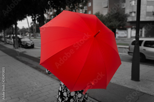 Back view of fashion woman with red umbrella walking on the street