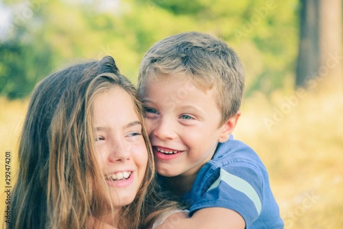 Принти на полотні Brother on top of sister hugging her and smiling and having fun while doing pigg