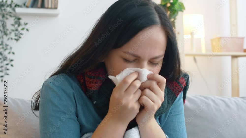 Sick woman with plaid sits on sofa and coughs. The girl has a cold and is treated at home on the sofa. 4k footage. Health care concept. Sick woman with plaid sits on sofa and coughs. The girl has a cold and is treated at home on the sofa. 4k footage. Health care concept.