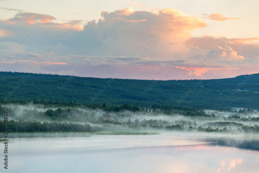 Fototapeta premium Sunset at a lake with fog in the woodland