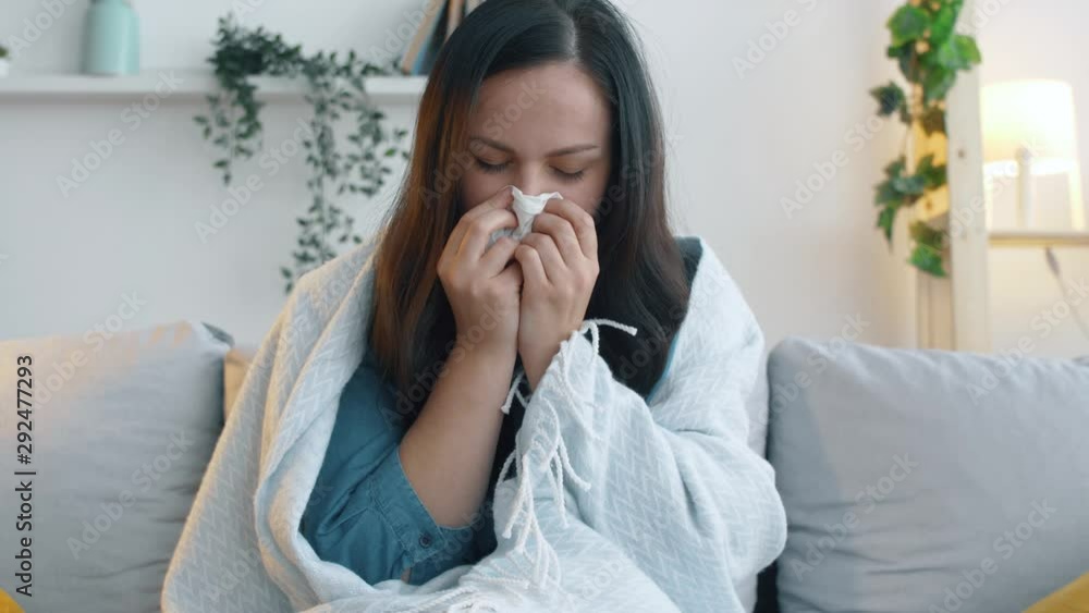 Sick woman with plaid sits on sofa and coughs. The girl has a cold and is treated at home on the sofa. 4k footage. Sick woman with plaid sits on sofa and coughs. The girl has a cold and is treated at home on the sofa. 4k footage.