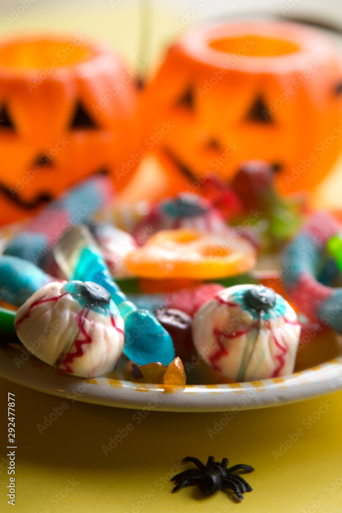 halloween candies with orange pumpkin in the background