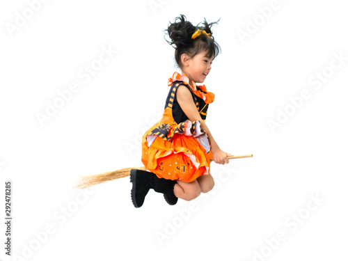 Asian children girl in pumpkin dress costume for Halloween decoration in Riding a broom white background