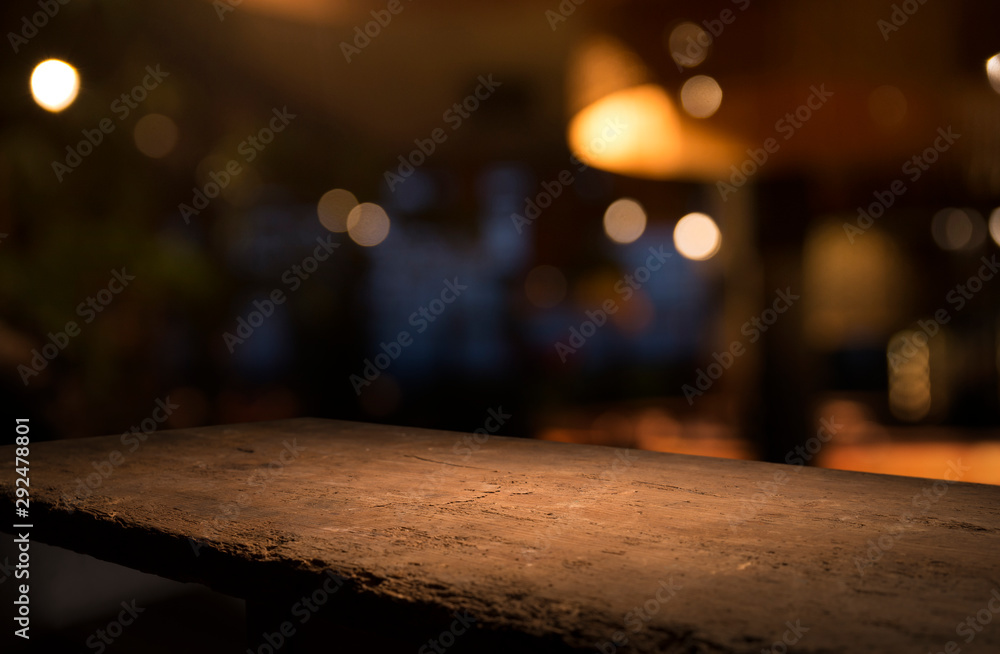 Empty wood table top on blur light gold bokeh of cafe restaurant in dark background Empty wood table top on blur light gold bokeh of cafe restaurant in dark background