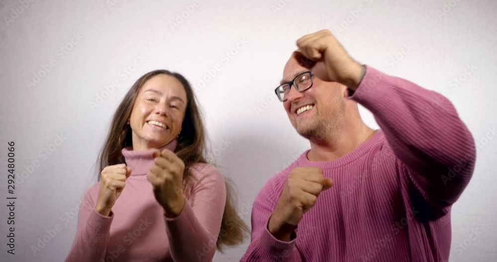 cheerful man and woman are rejoicing and dancing in room, showing thumbs up, kissing cheerful man and woman are rejoicing and dancing in room, showing thumbs up, kissing
