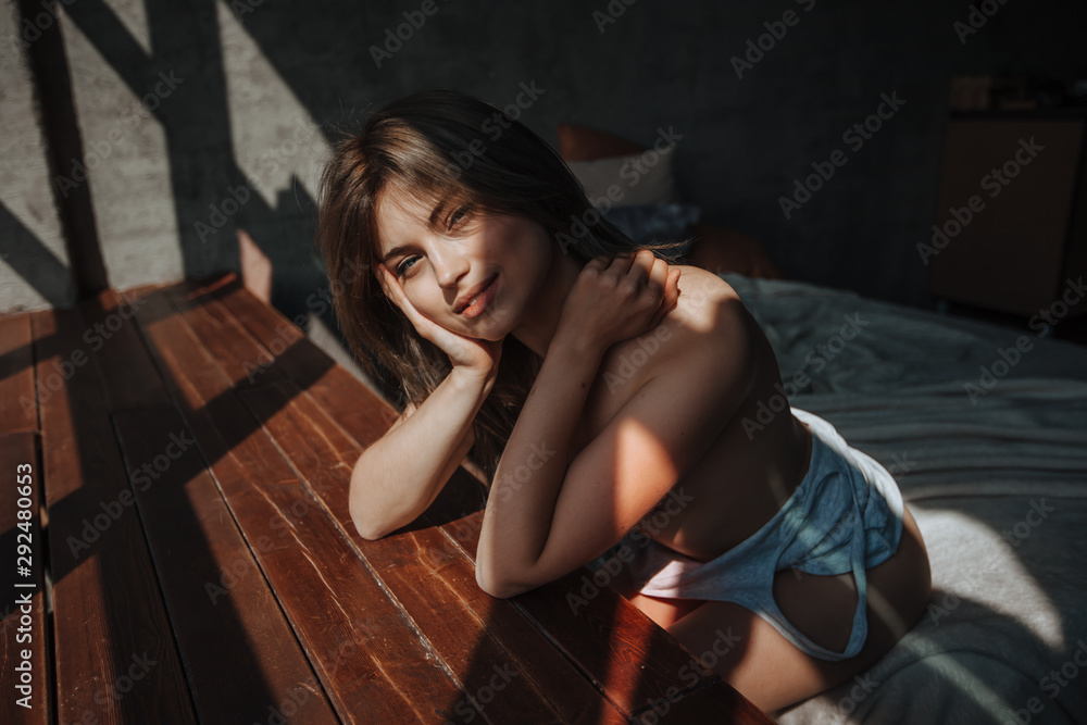 Sexy girl sitting on the bed in the sunlight Sexy girl sitting on the bed in the sunlight