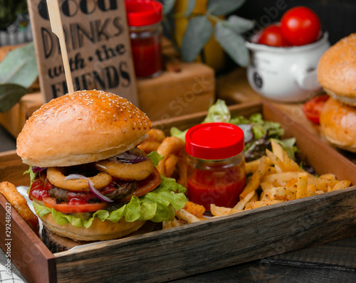 Hamburger with onion rings and fries