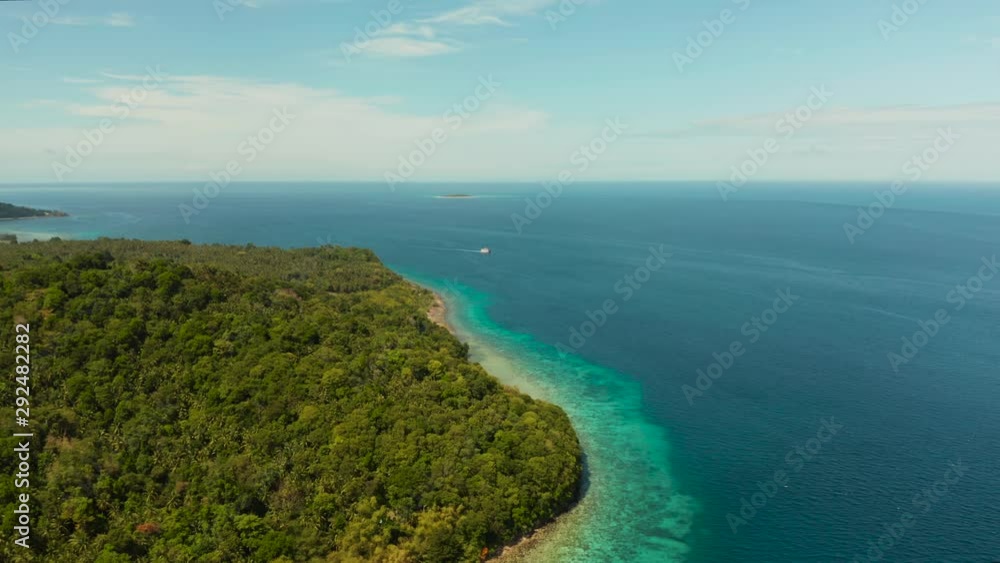 Green island with coral reef. Coast of Camiguin Island, Philippines, view from above. Seascape in sunny weather. Green island with coral reef. Coast of Camiguin Island, Philippines, view from above. Seascape in sunny weather.