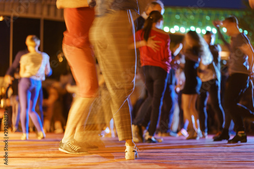 Defocused photography of dancing people. Night city street lifestyles concepts. 