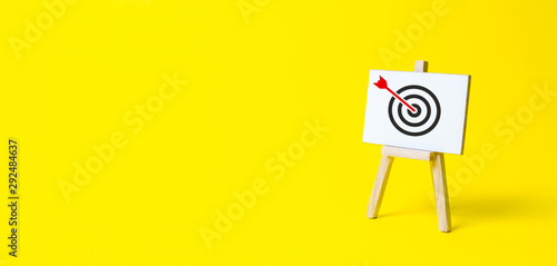 Sign stand with an arrow in the target on a yellow background. Hit exactly on center. Tactics of advertising targeting. advertise campaigns. Goal Achievement and Purposefulness photo